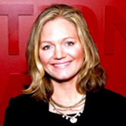 Smiling woman in front of red background.
